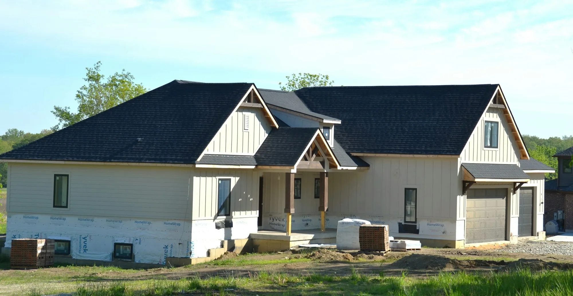 Roofers working along the eave of a shingle roof